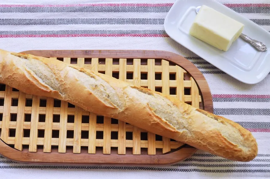 baguette on cutting board with butter