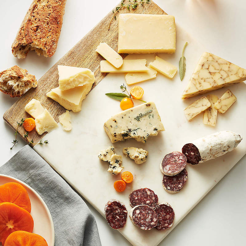 Our favorite boards for charcuterie boards: This minimalist mango-wood and marble board at Crate & Barrel