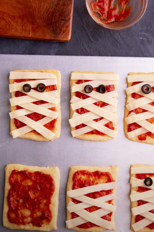 Halloween Mini Mummy Pizzas made easy using pre-made crescent roll dough | via Pillsbury