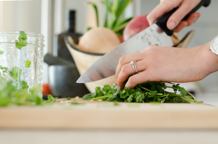 7 smart kitchen habits for home cooks | hand cutting herbs on cutting board